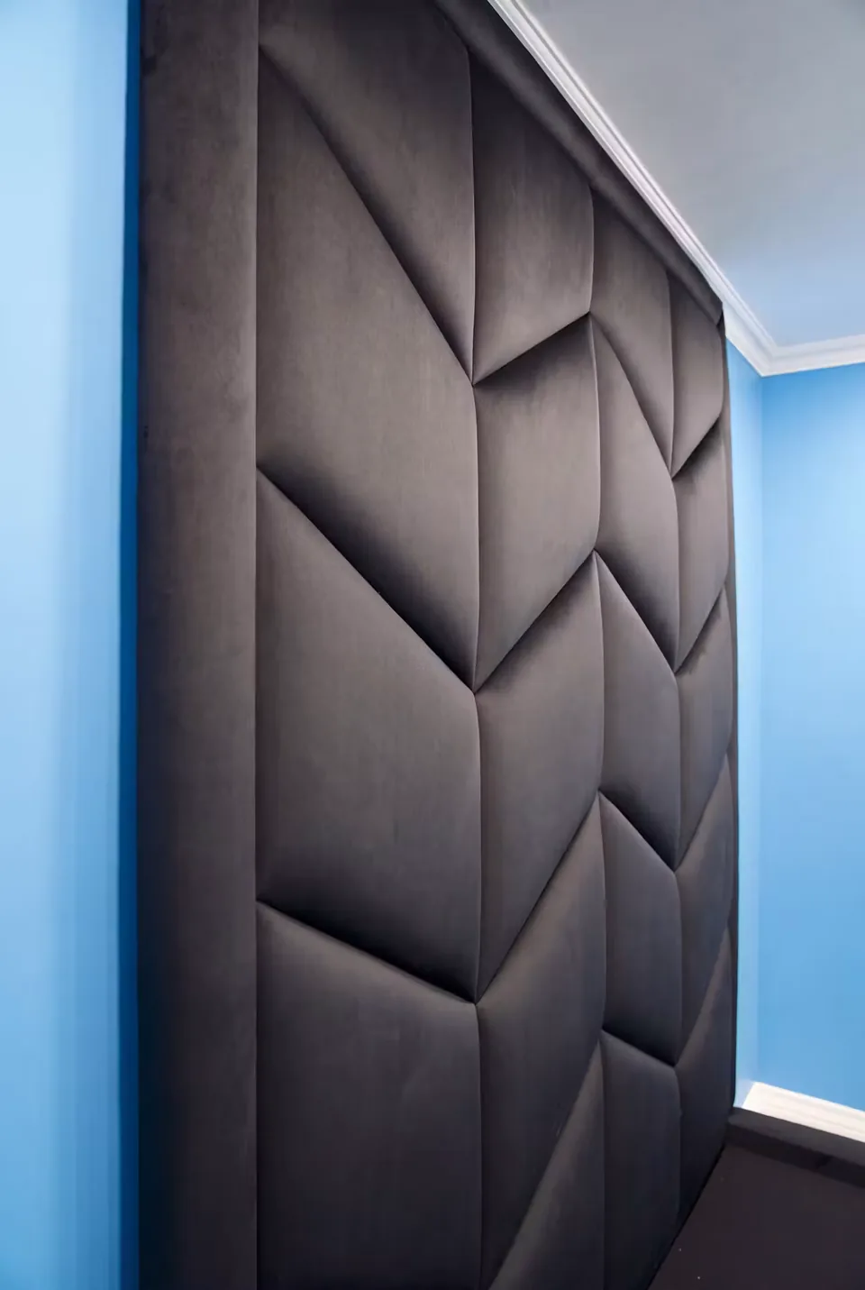 Close view of the raised black chevrons beneath the ceiling moulding