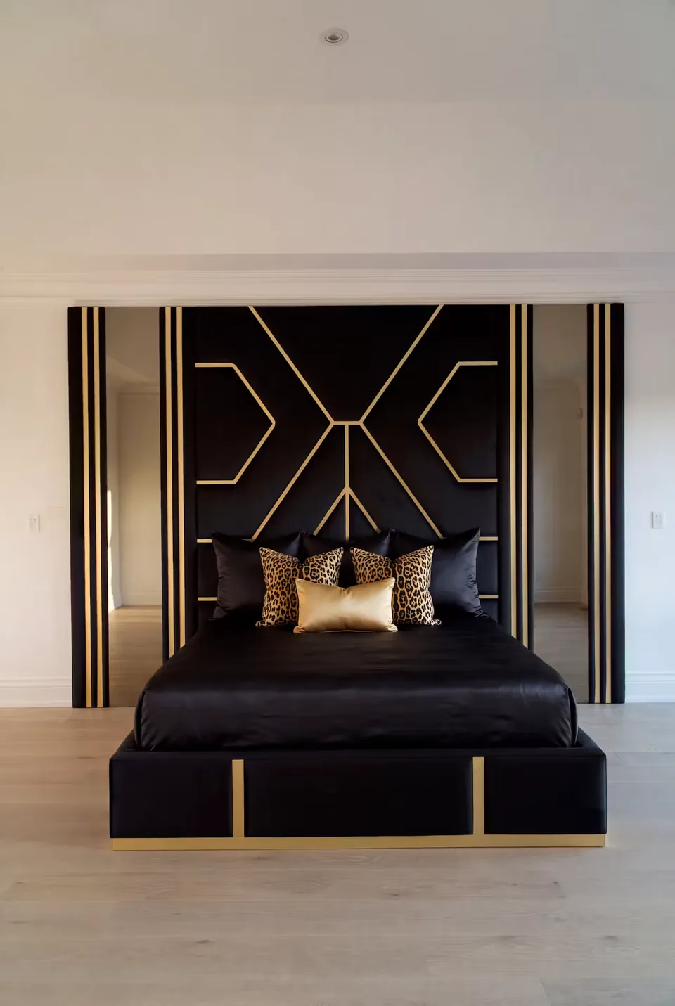 Full view of the dark upholstered bed under the gold-lined backdrop