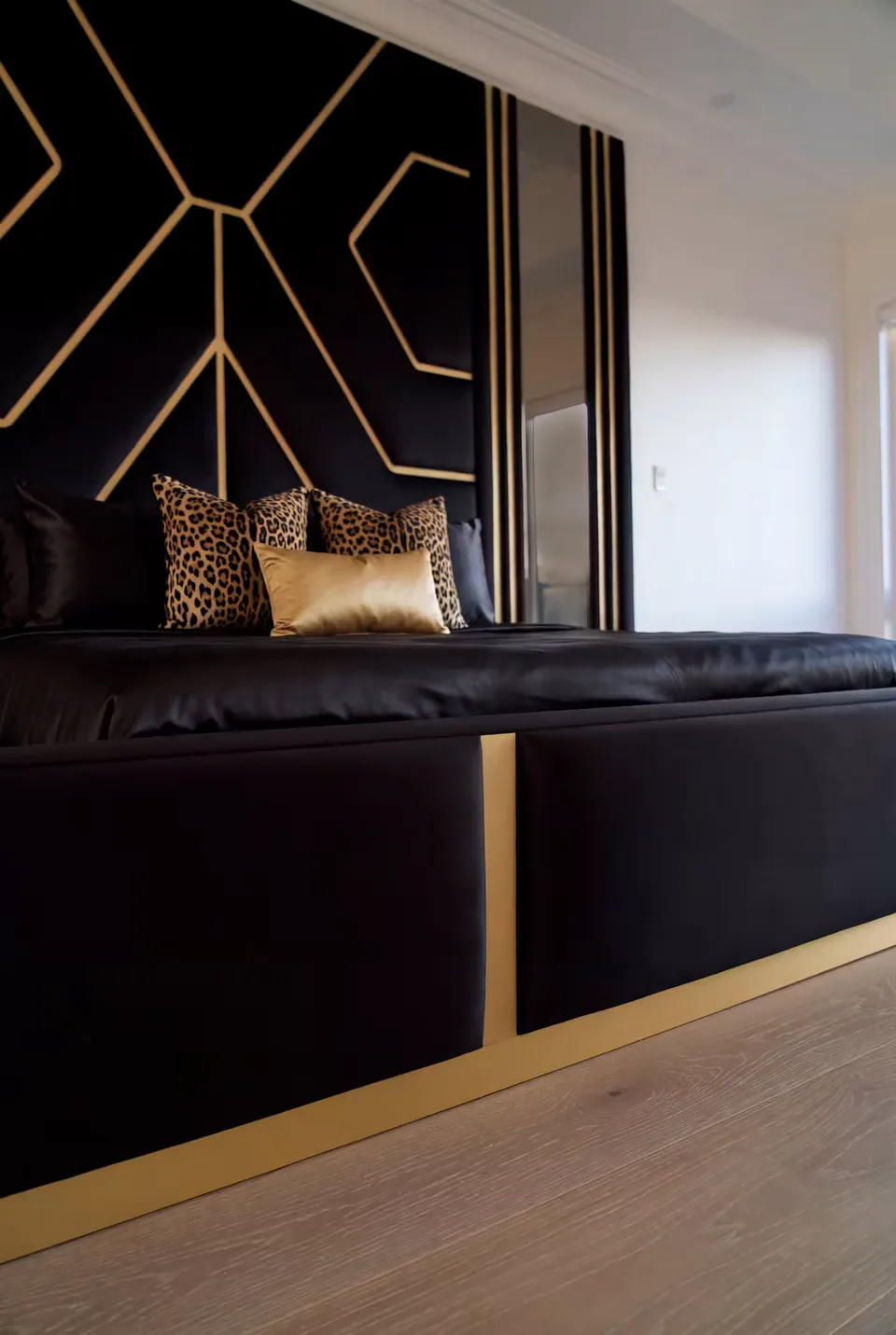 Detail of the gold-trimmed black upholstered side rail