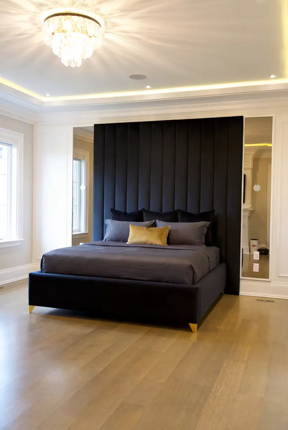 Angled view of the black padded frame and gold-edged mirror surround