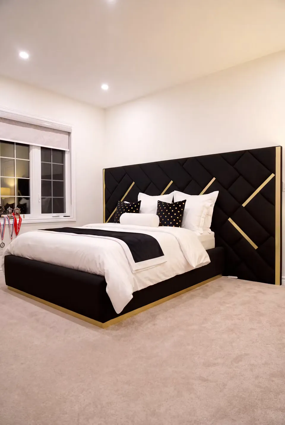 Full angled view of a black bed beneath diagonal woven upholstery with gold accents.
