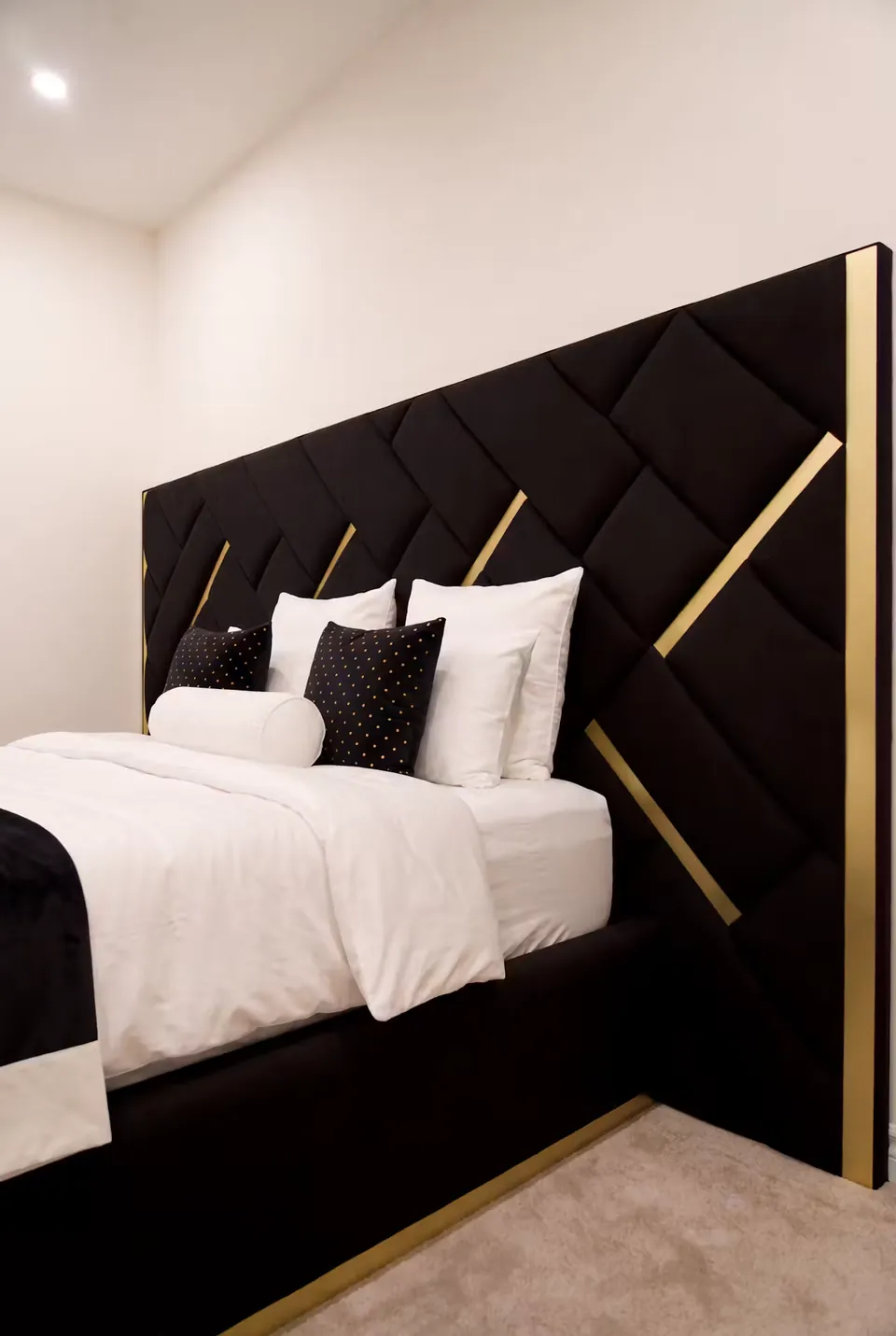 Side view of the black upholstered frame and gold-edged geometric headboard.