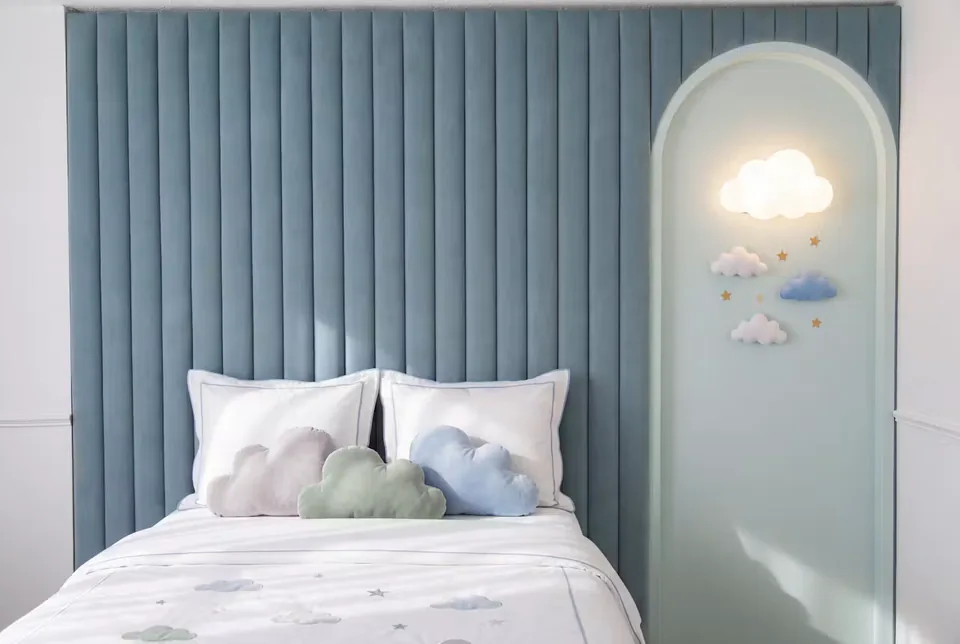 Front view of the blue padded bed beneath the illuminated cloud alcove