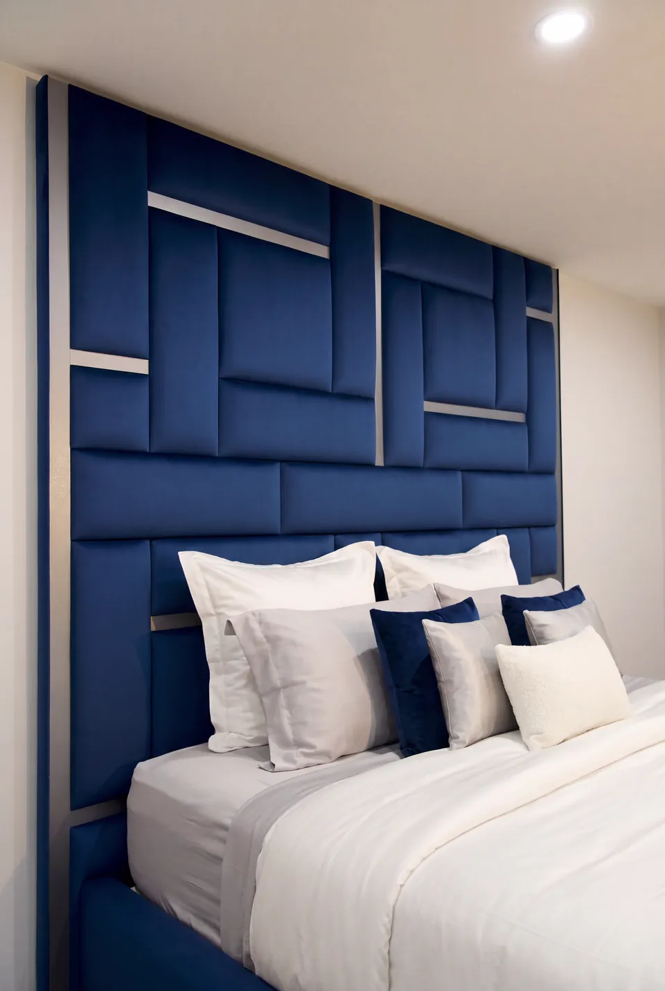 Side view of layered pillows against the blue upholstered wall.