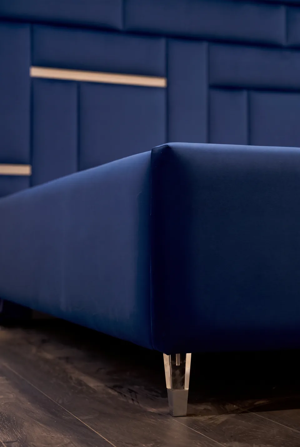 Close view of the blue bed frame corner and metallic leg.