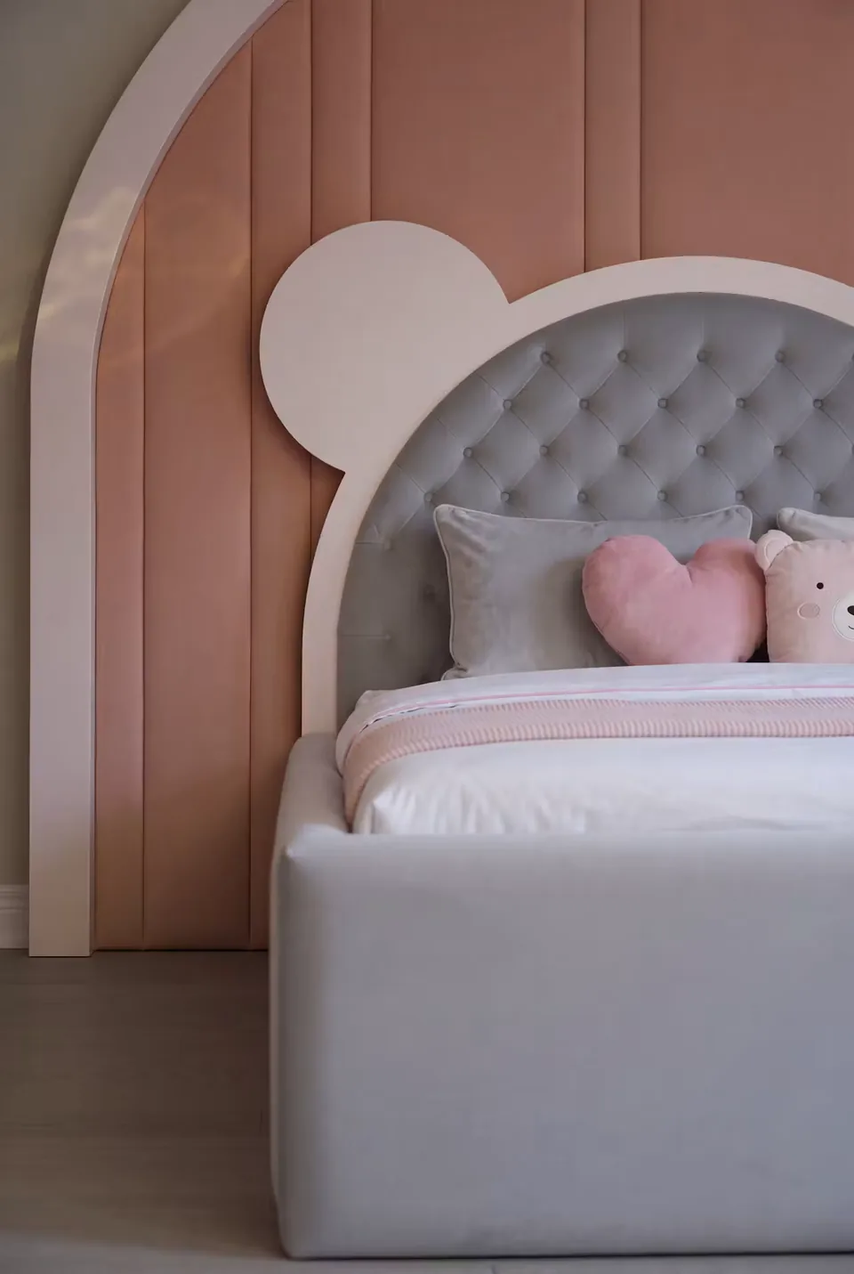 Detail of the bear headboard and pink cushions