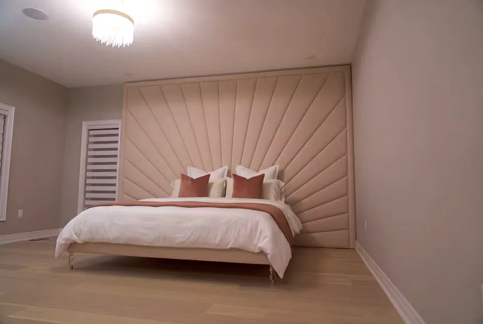 Wide view of the blush sunray bed beside white window shutters