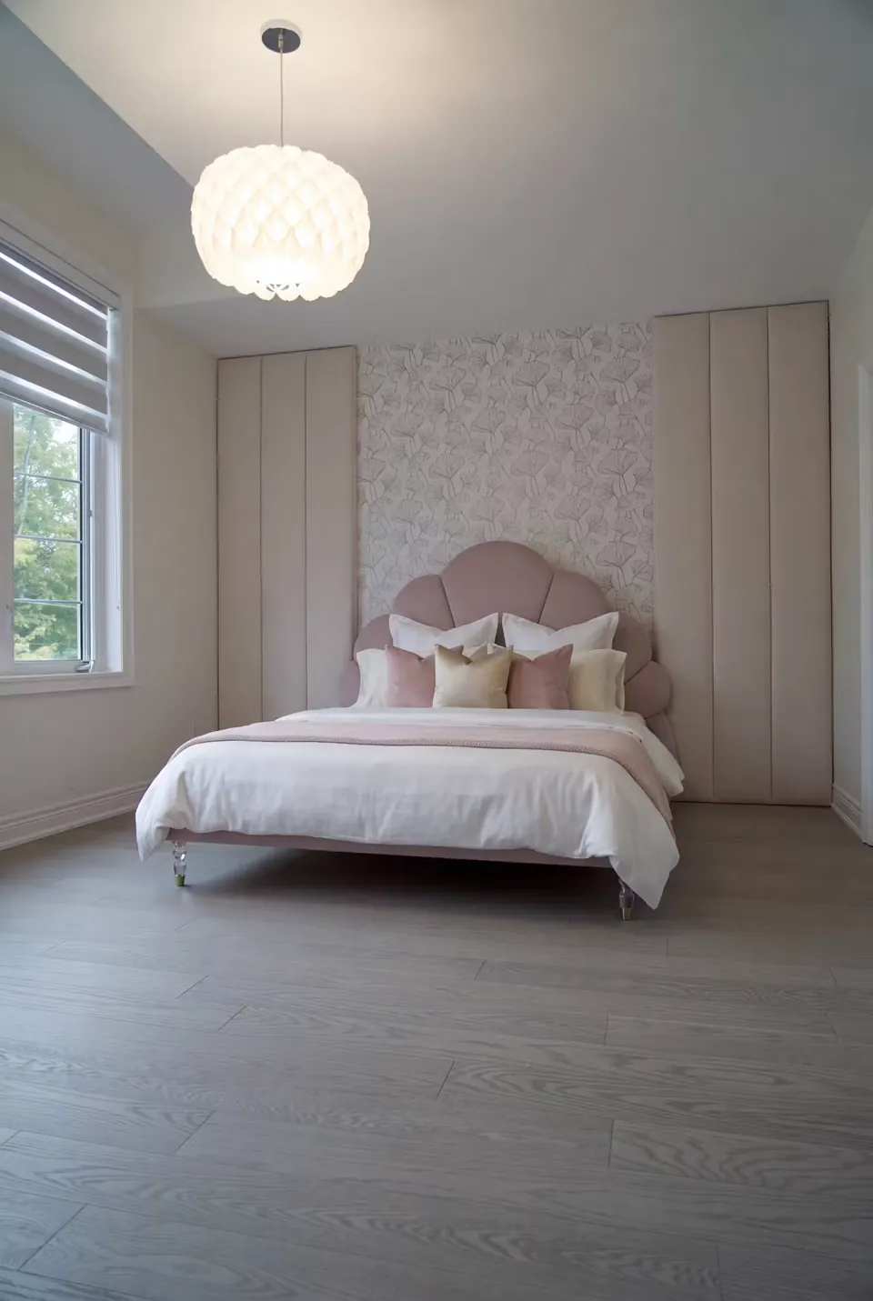Wide angled view of a pink petal bed against floral wallpaper.