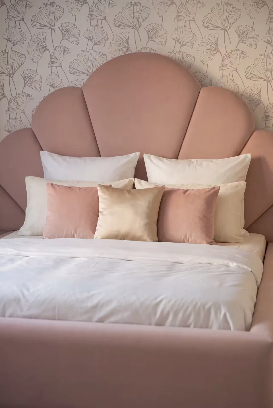 Front detail of the blush petal headboard with pink and cream pillows.
