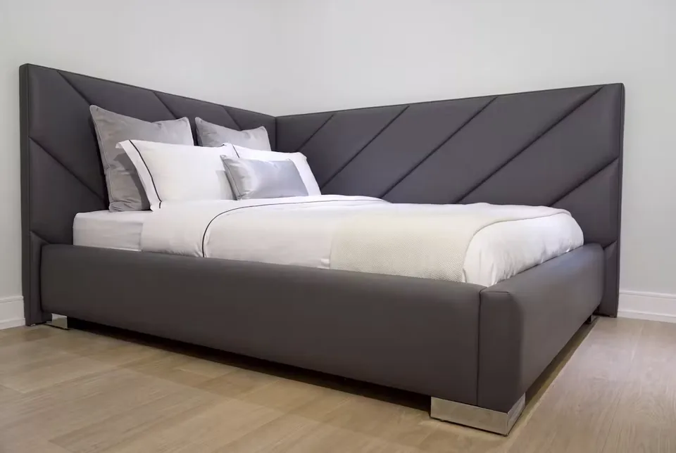 Angled view of the charcoal padded frame on metal-toned supports
