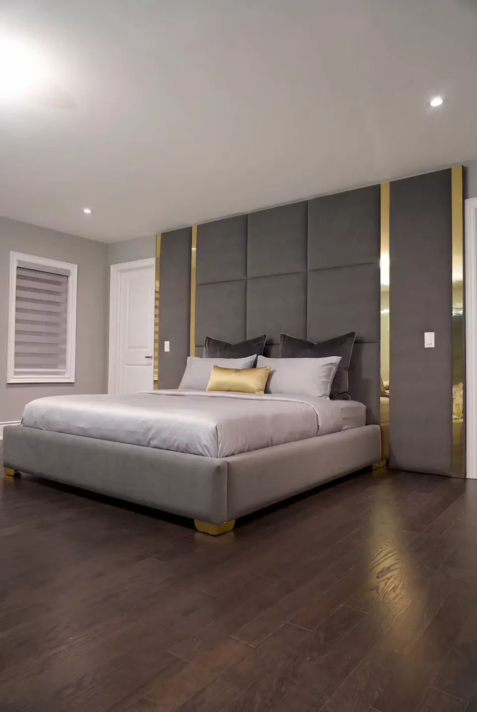 Angled view of the grey frame and gold-divided upholstered wall
