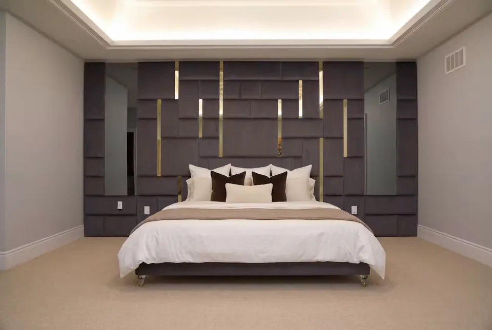 Full front view of a charcoal bed beneath a wide padded grid with gold divisions and mirrors.