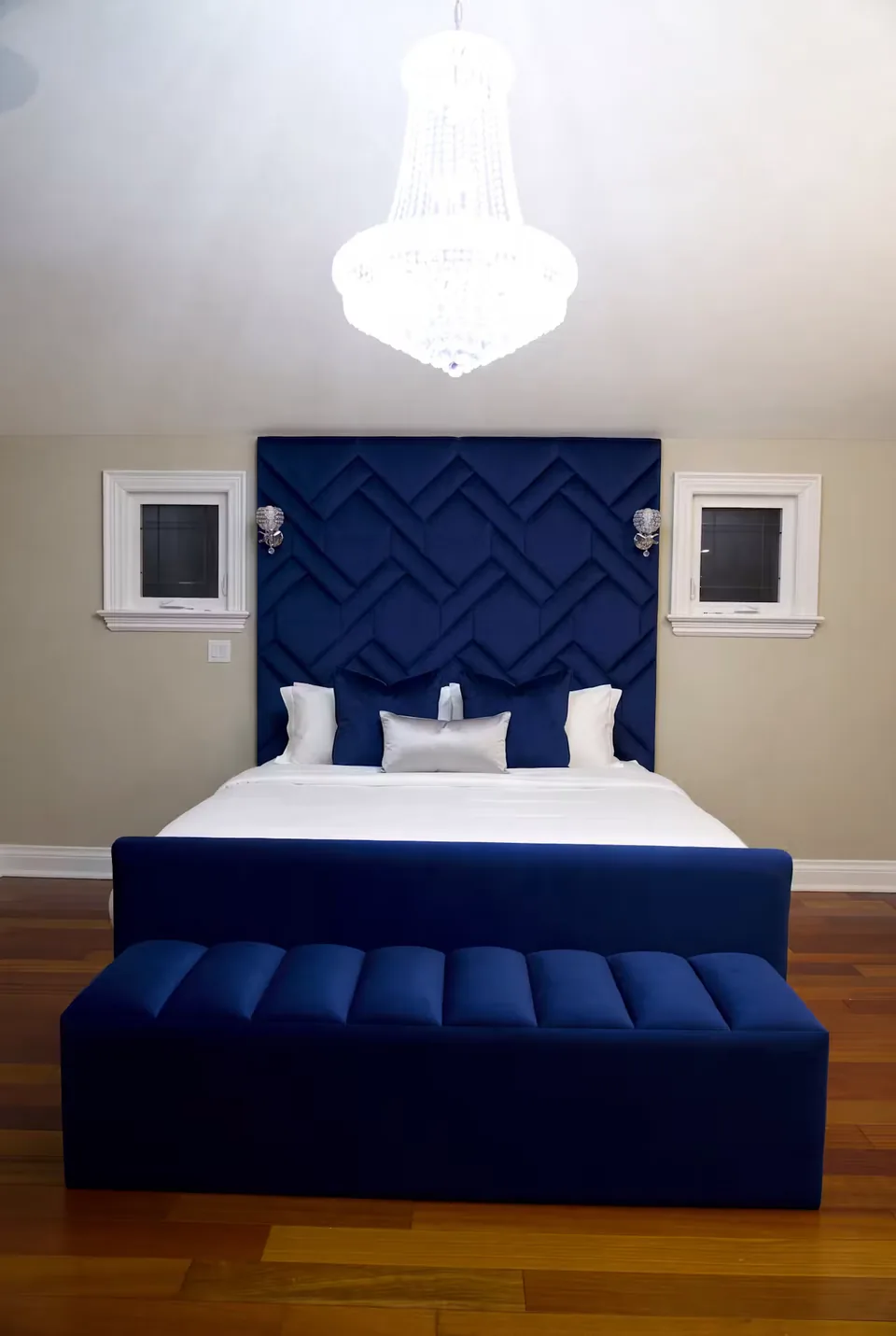 Full cobalt upholstered bed and channelled bench beneath a woven geometric headboard