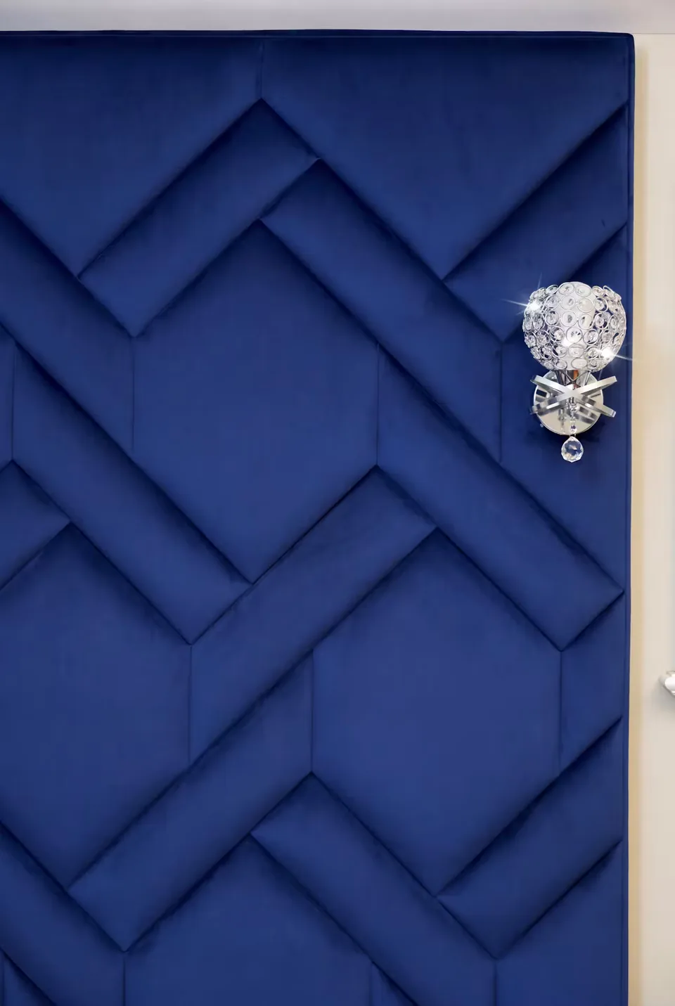 Close view of the raised overlapping blue panels and wall lamp