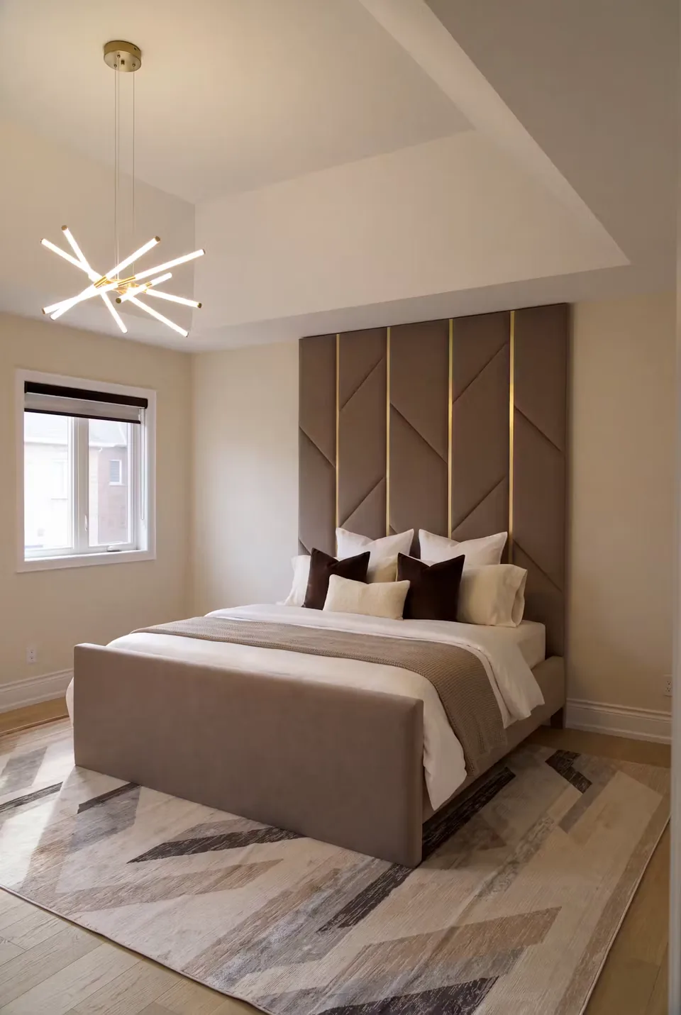 Full angled view of the cocoa bed with a broad footboard below the geometric padded wall.