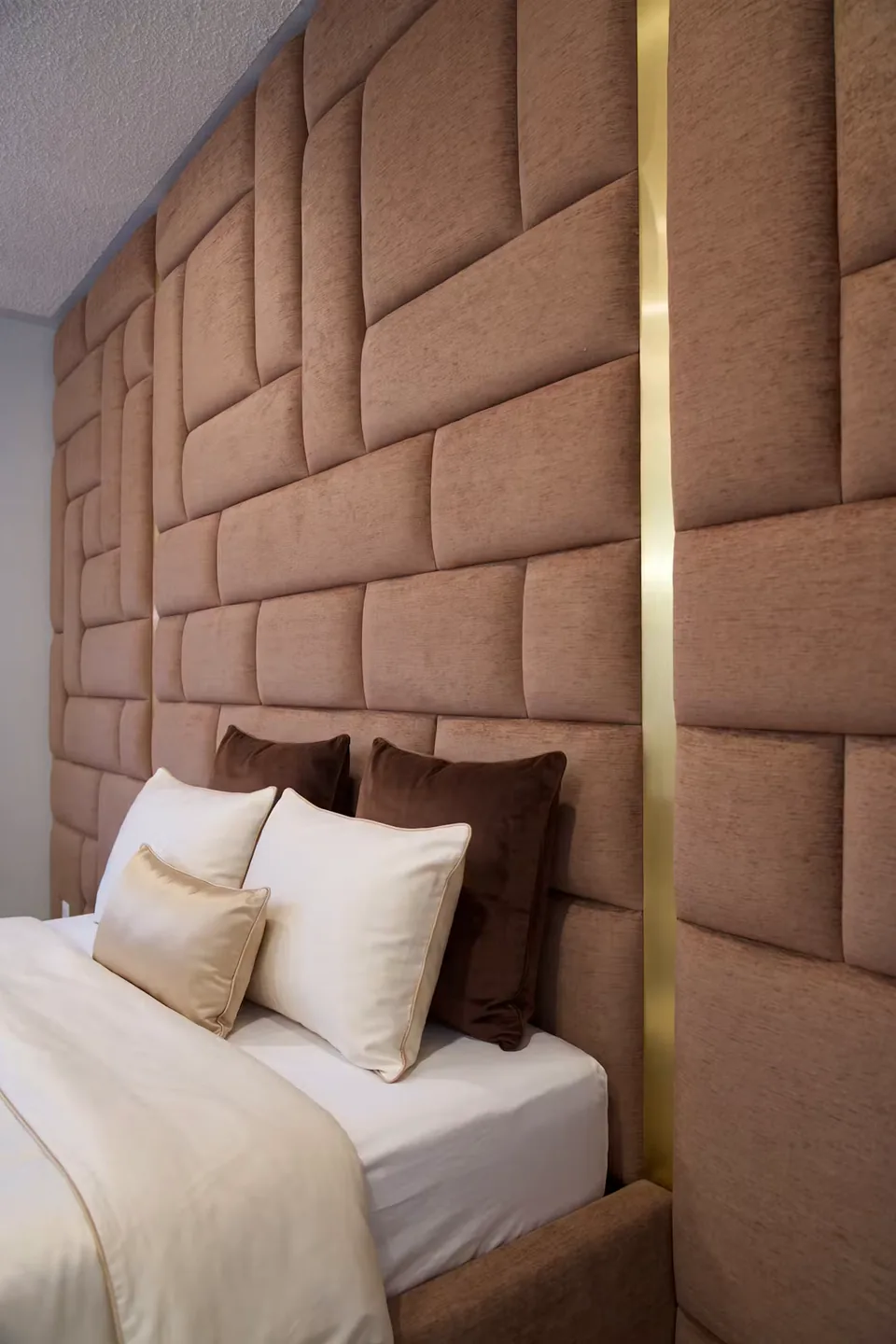 Portrait detail of the cocoa pads and vertical gold-toned band behind the bed