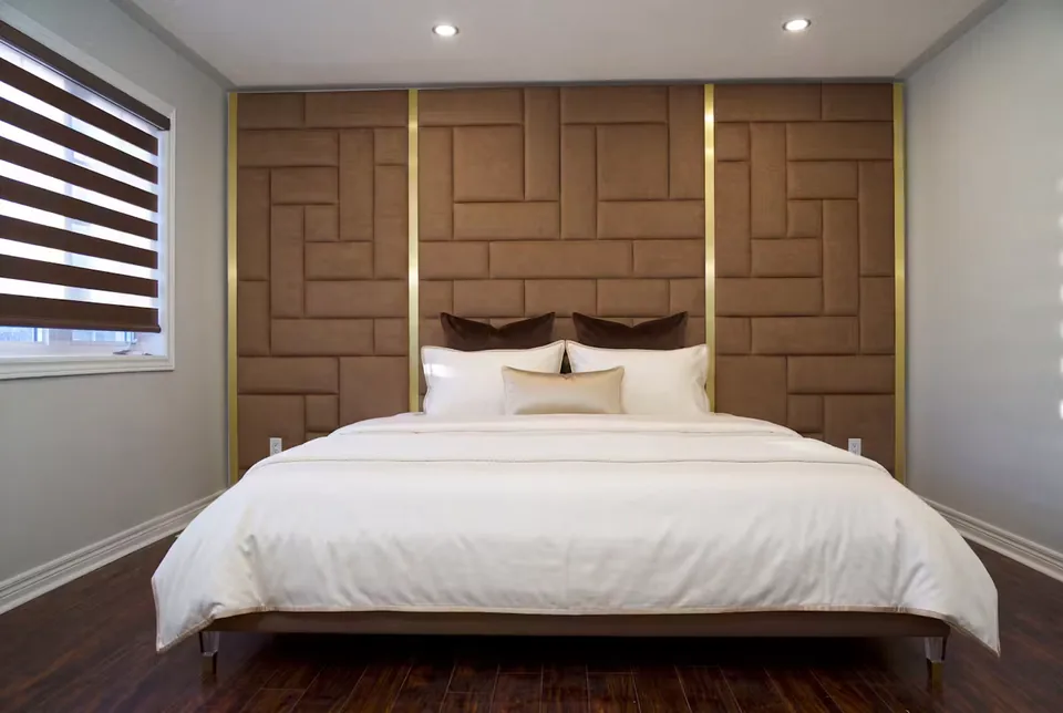 Wide front view of the bed and staggered brown upholstered backdrop