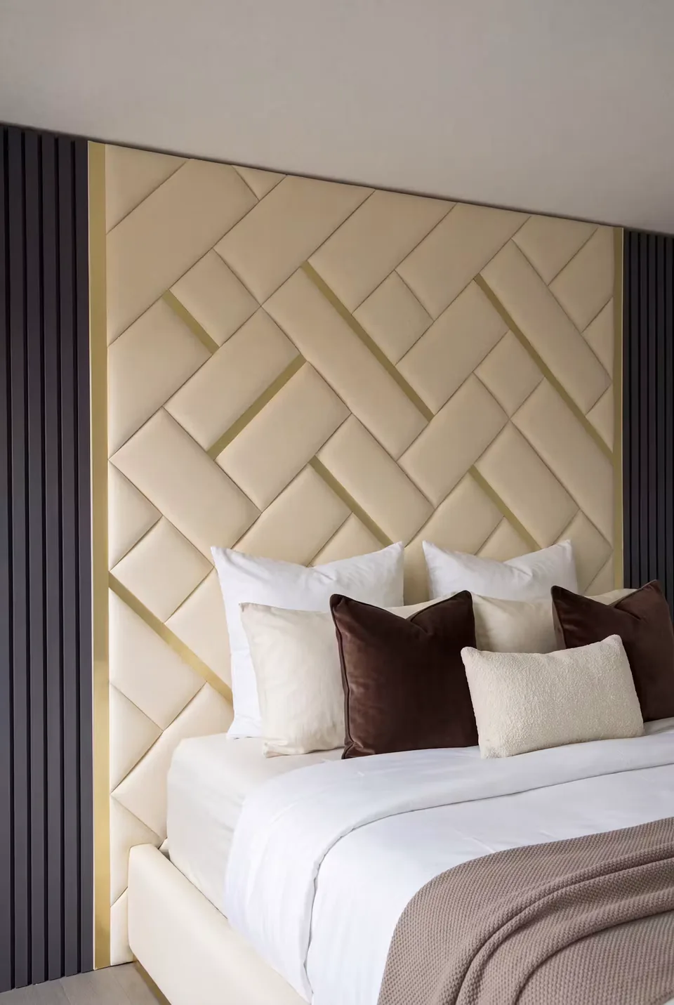 Cream basketweave panels with gold accents above layered white and brown pillows.