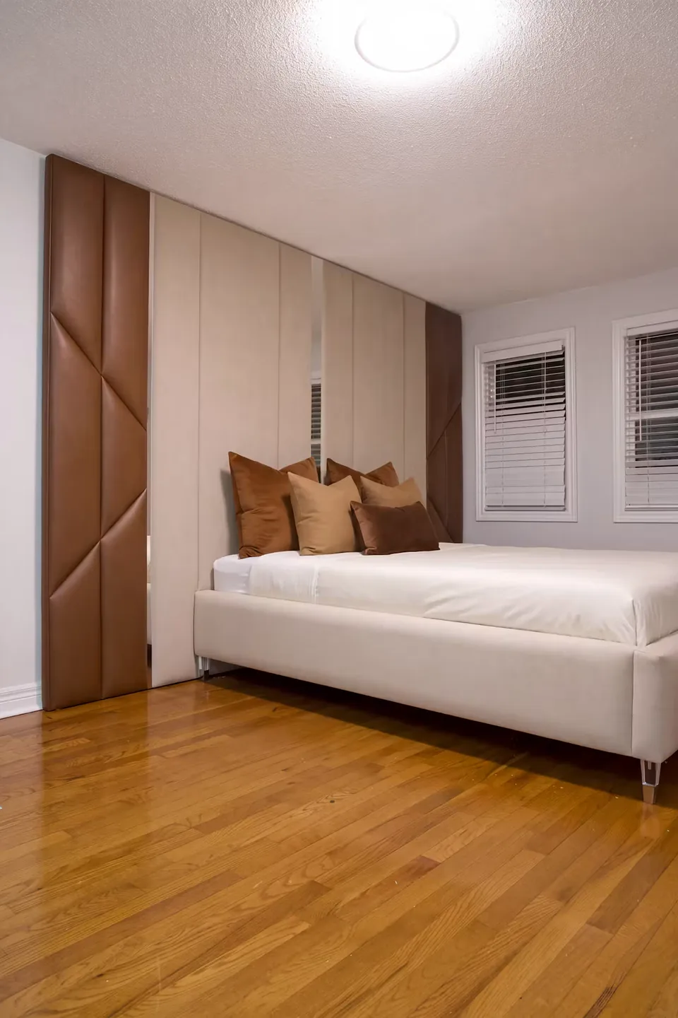 Angled view showing the greatest available portion of the cream bed and tall panel wall
