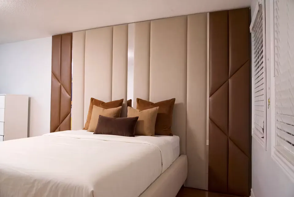 Wider view of the cream bed between cocoa upholstered side panels