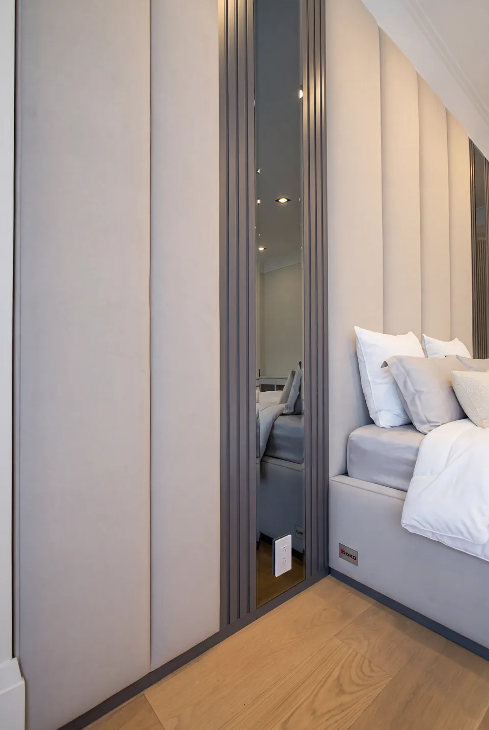 Side view of the cream bed and its tall padded wall panels.