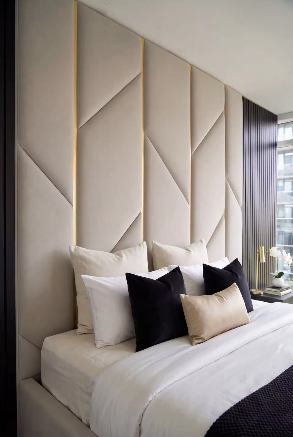 Close view of cream padded wall panels divided by gold-toned angled lines