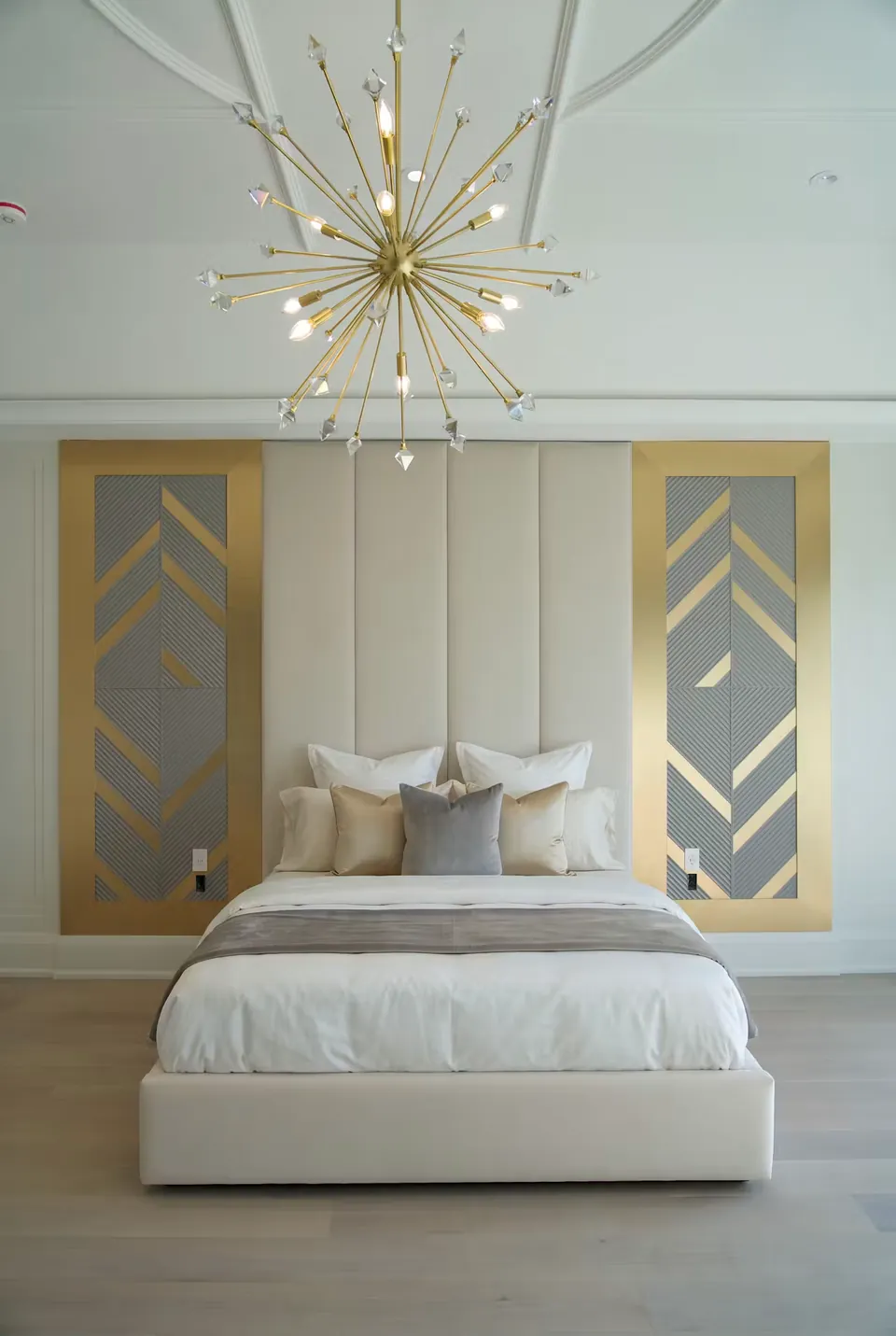 Full front view of a cream upholstered bed with vertical padding and grey-and-gold side panels.