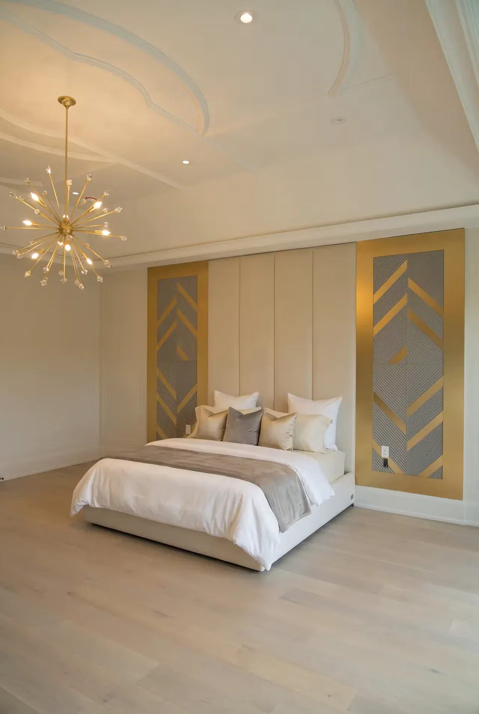 Side view of the cream bed within its geometric gold and grey wall composition.