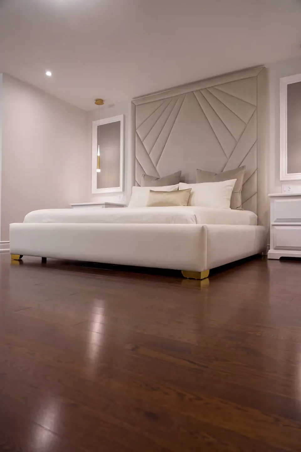 Full view of the cream bed and framed ray headboard with the bench alongside