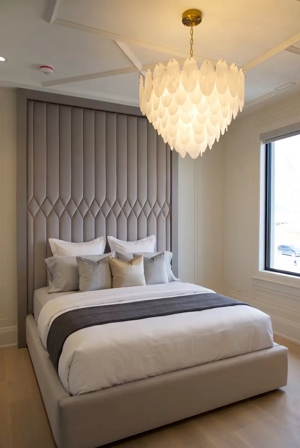Full angled view of a grey upholstered bed beneath channels ending in padded diamonds.