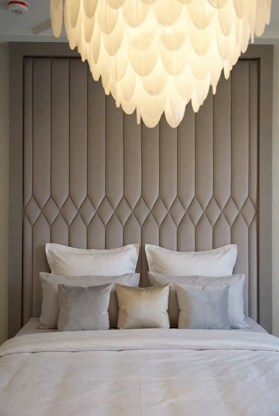 Front detail of the diamond channel headboard and layered neutral bedding.