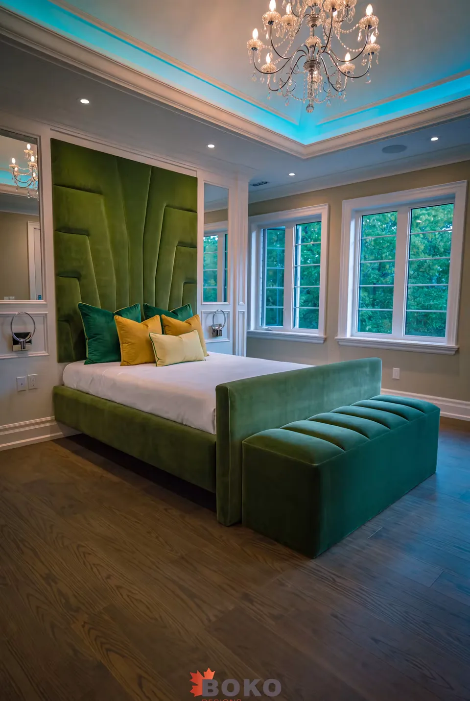 Wide room view of the emerald bed and bench beside the windows