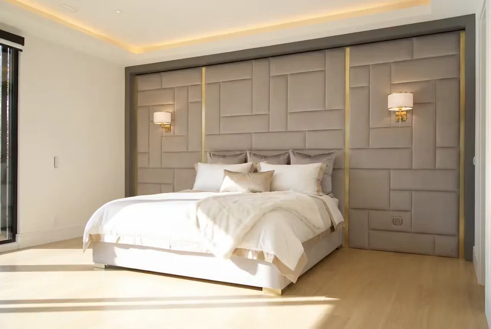 Wide sunlit view of the greige bed and padded block backdrop