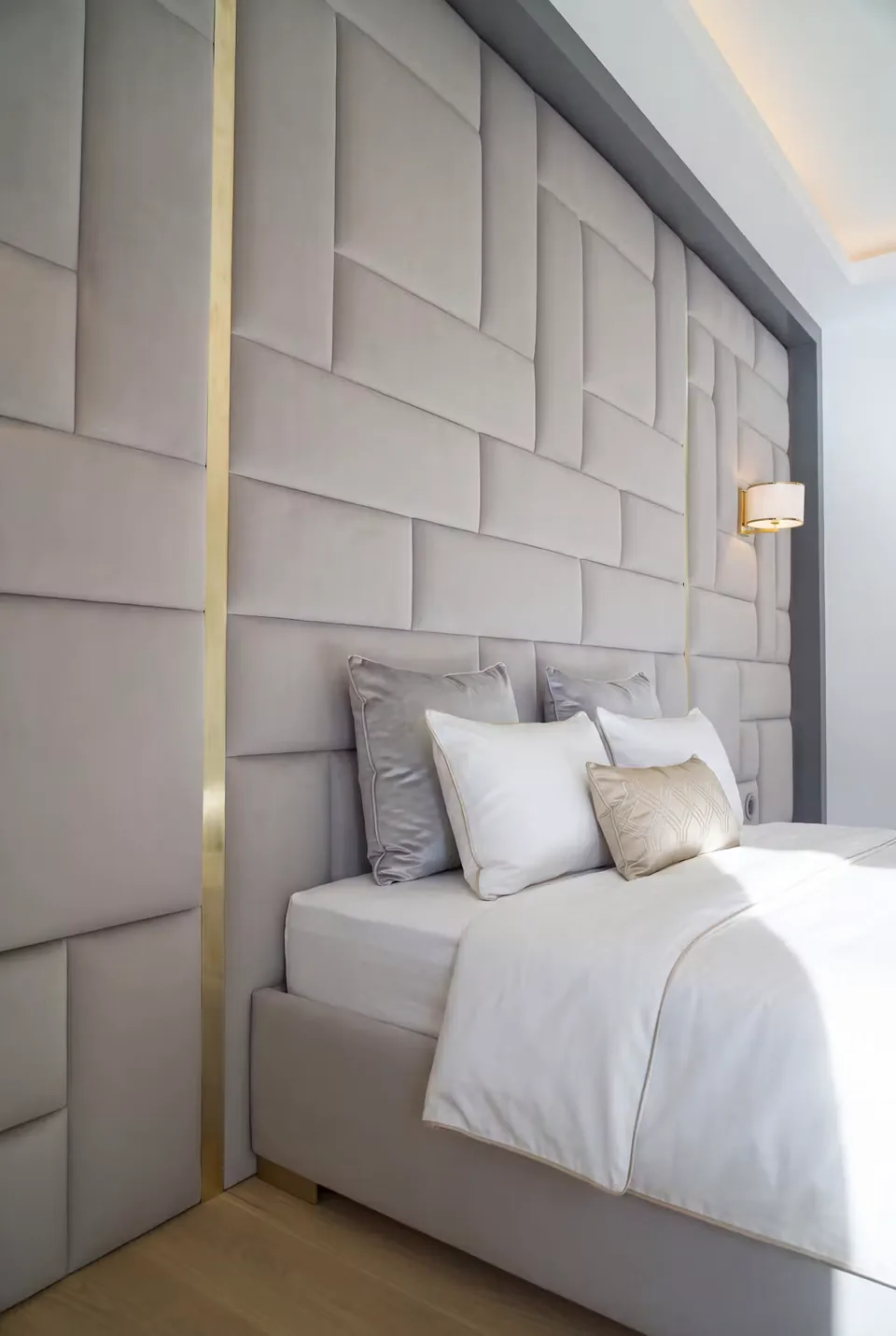 Close angled view of the padded rectangular wall beside the pillows