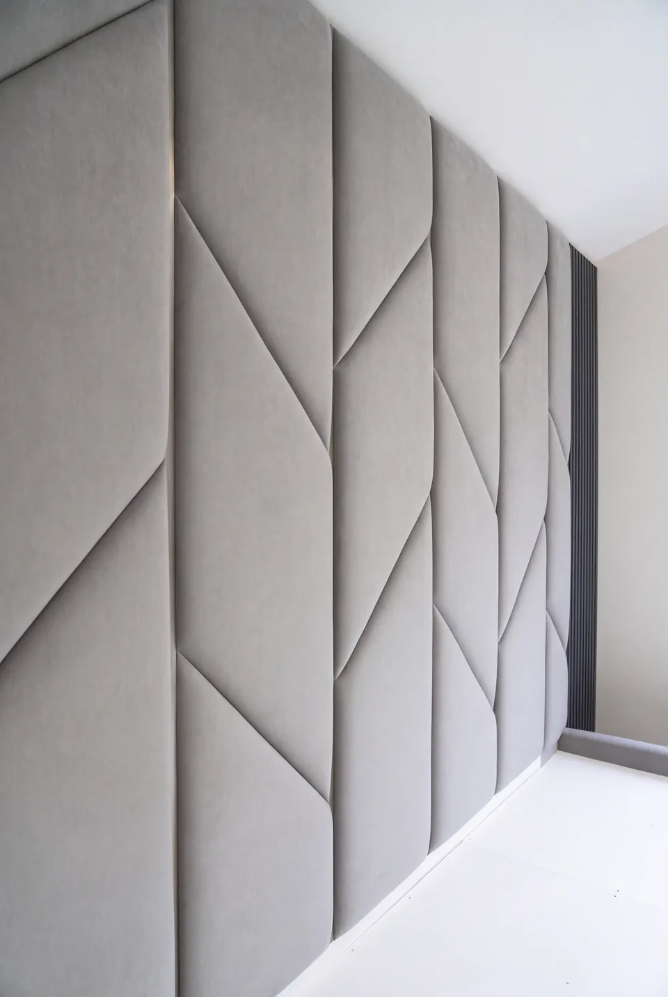 Close view of the diagonal seams in the greige upholstered panels