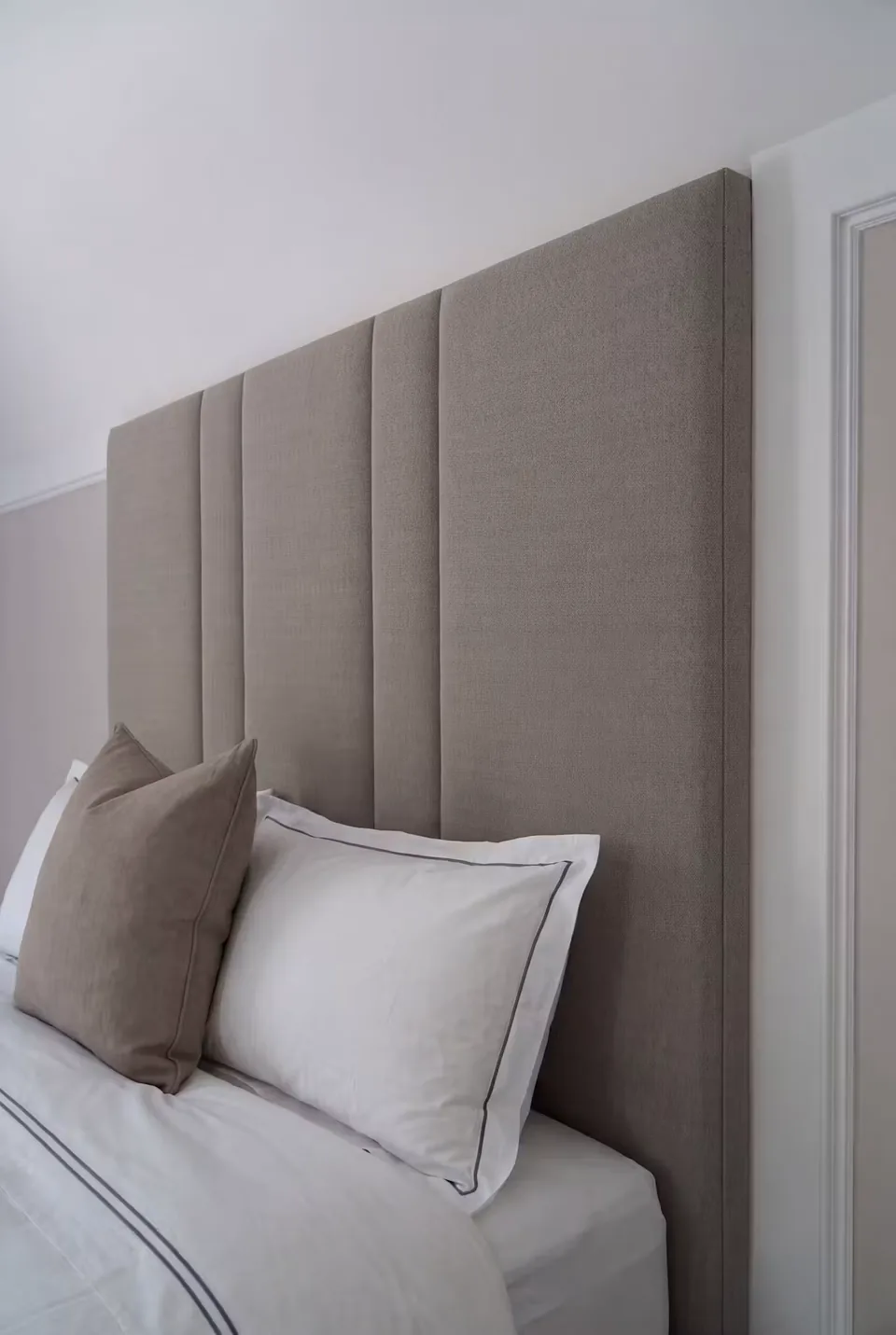Close side view of the broad greige headboard channels