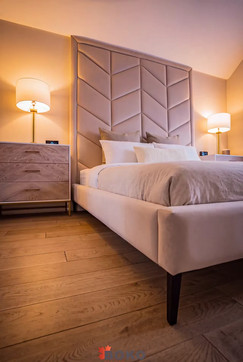 Side view of the greige bed and tall chevron headboard