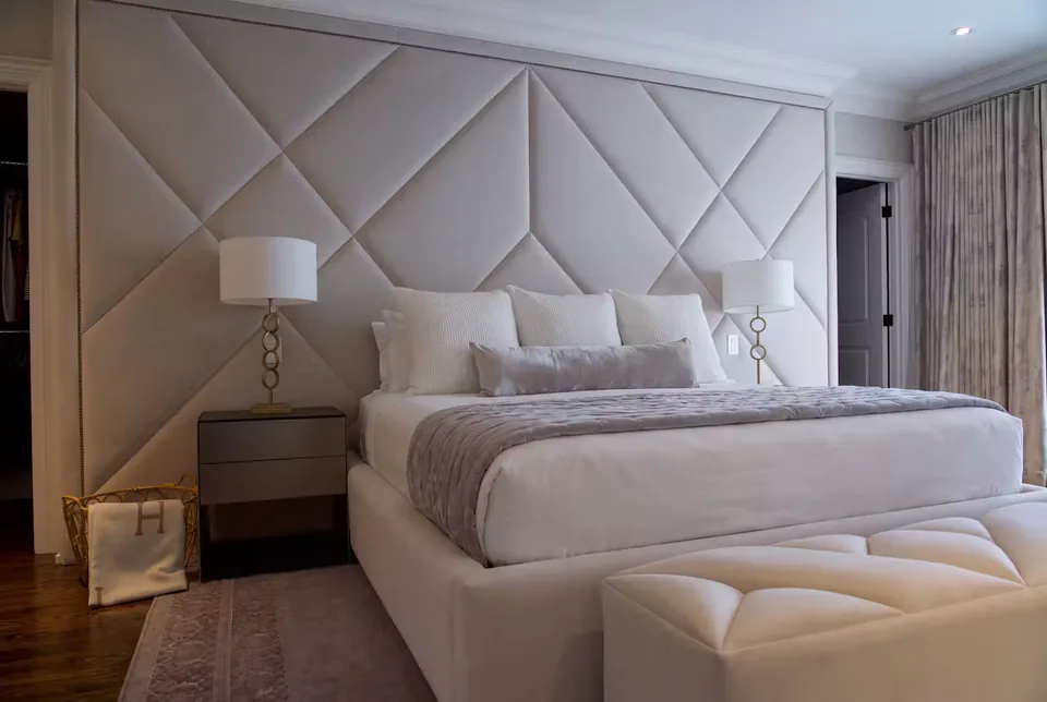 Angled view of the greige headboard wall and matching frame