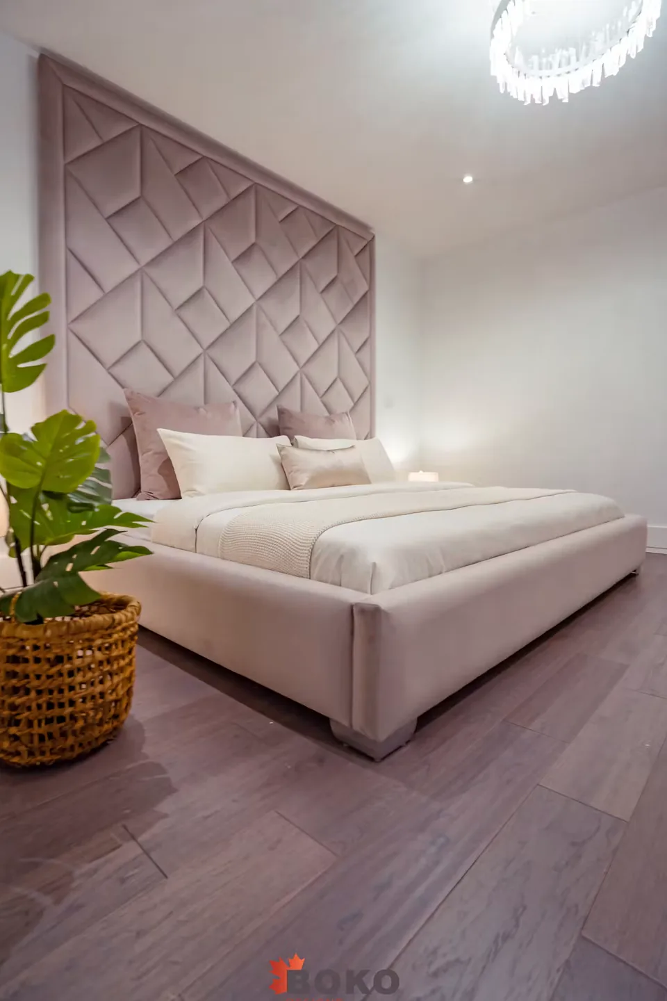 Full angled view of the greige bed and diamond-patterned headboard