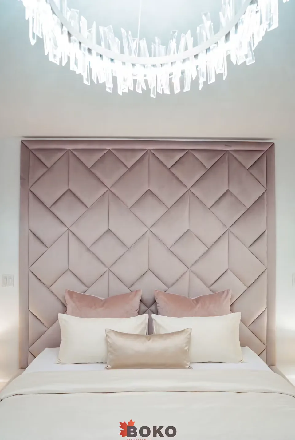 Front detail of the greige geometric headboard beneath the ceiling light