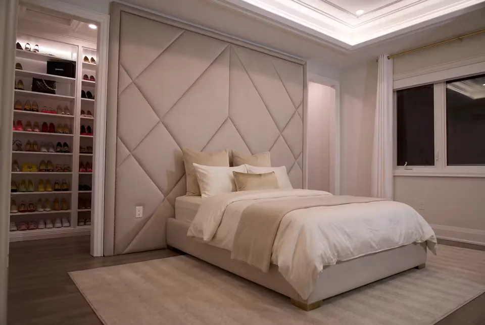 Full bedroom view with large diamond panels and a pale bed