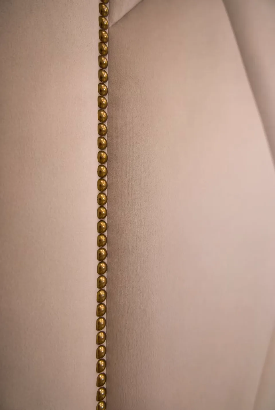 Detail of the gold decorative edge along the upholstered wall