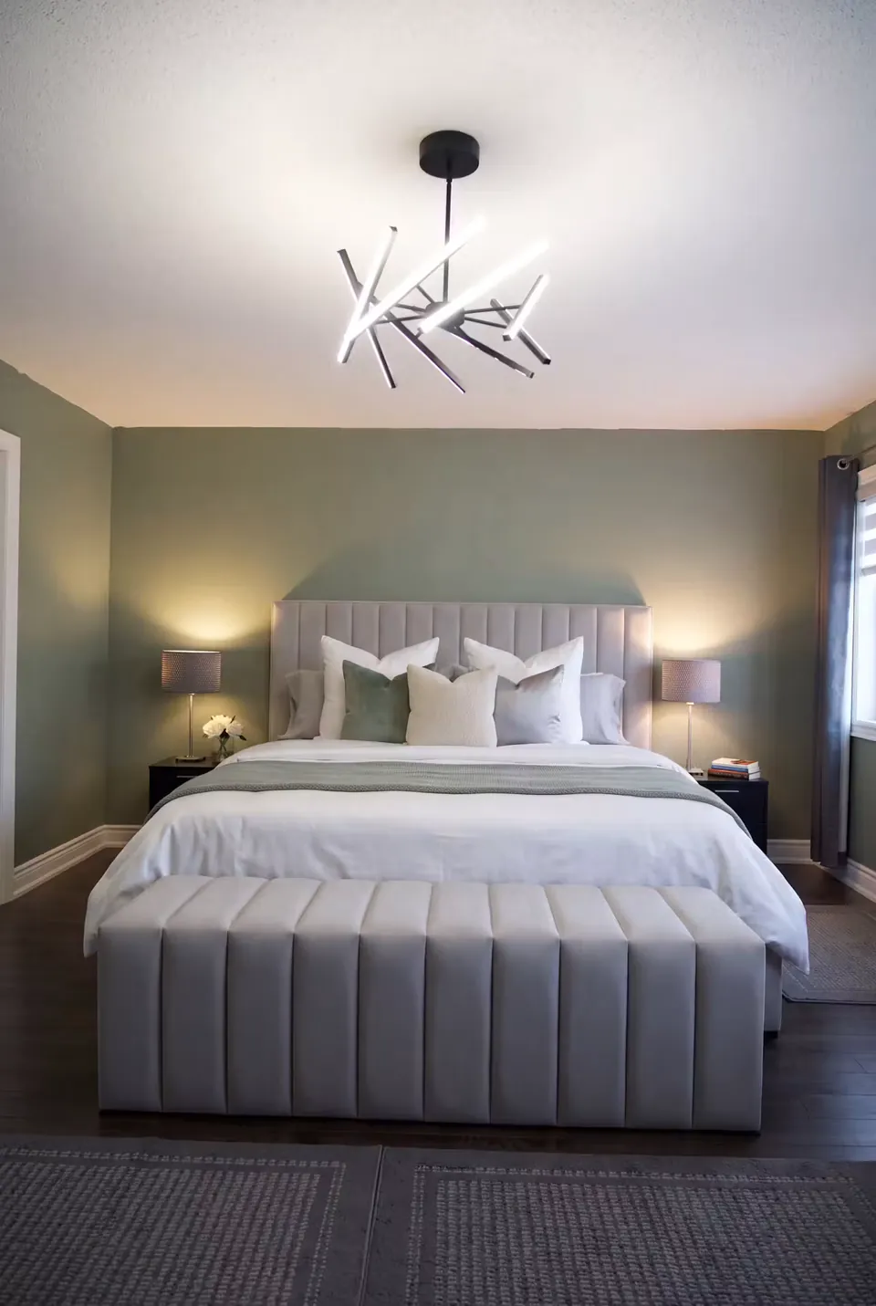 Full front view of a grey channel bed and matching bench against muted green walls.