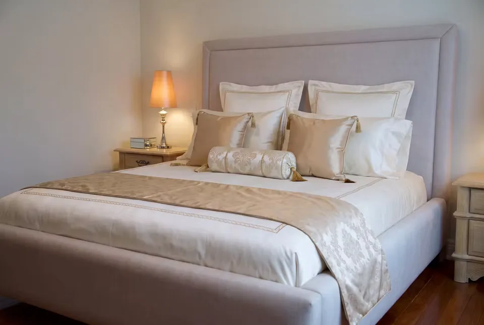 Angled view of a grey framed headboard and matching upholstered bed