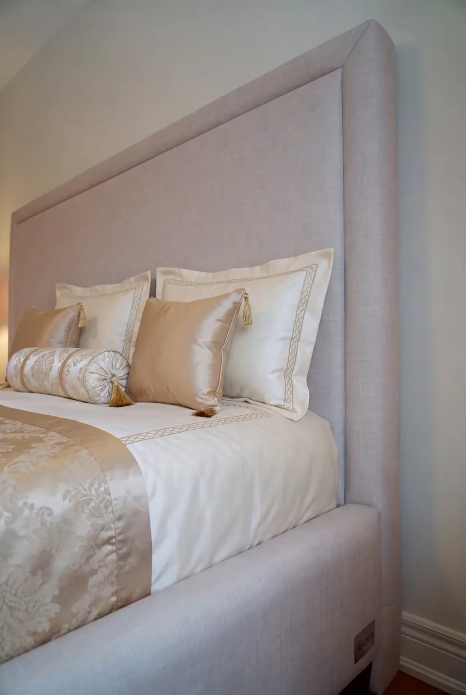 Close view of the padded grey headboard border and its plain centre