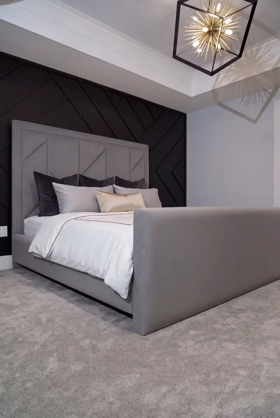 Angled view of the grey bed and patterned headboard