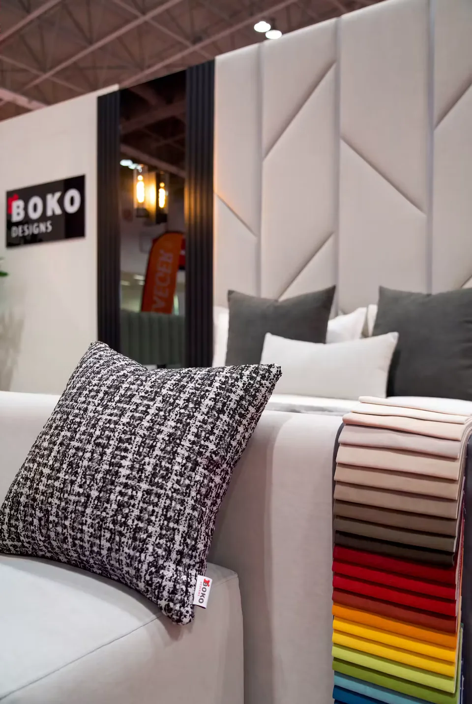 Fabric swatch book in many colours and a black-and-white tweed cushion at the BOKO Designs booth