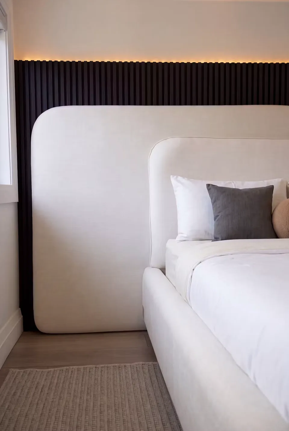 Close view of the broad pale headboard below black vertical slats