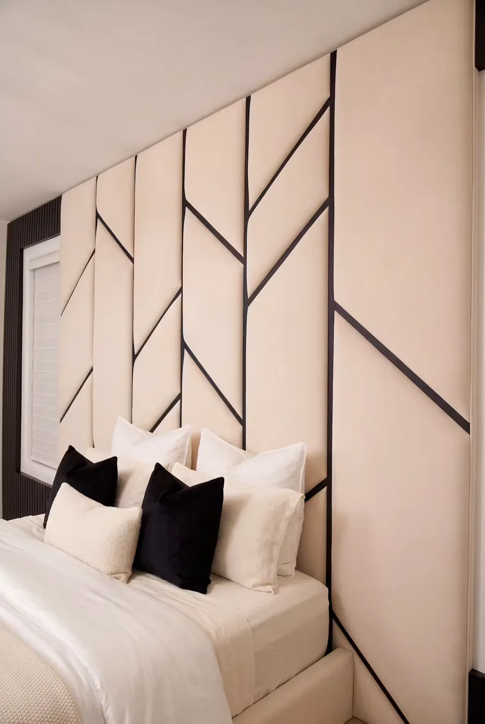 Close view of ivory upholstered wall panels crossed by slim dark diagonal lines