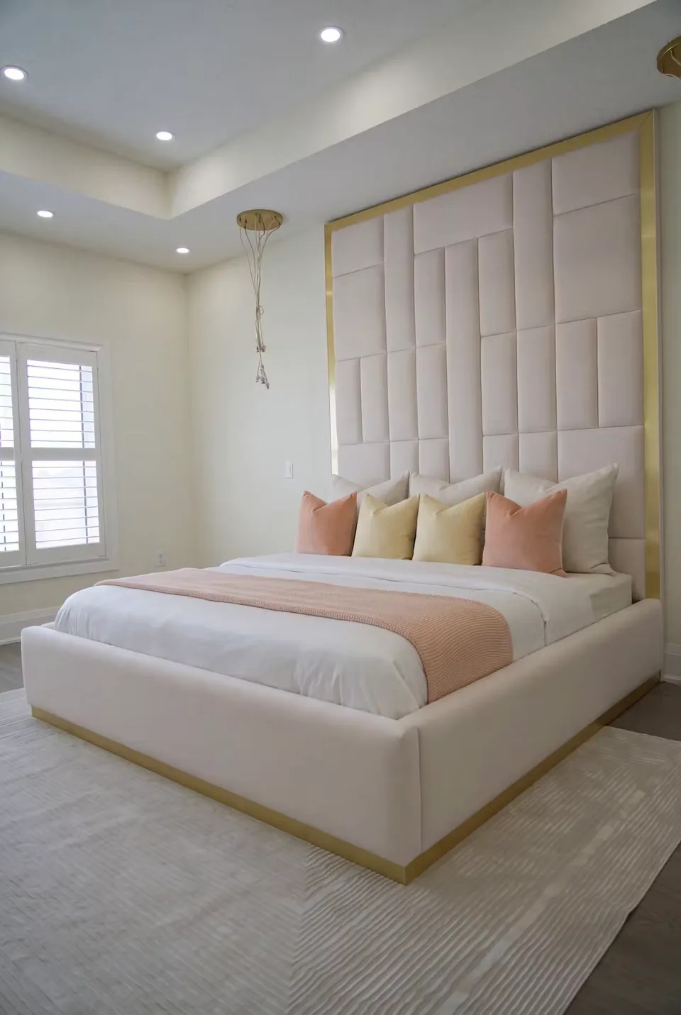 Custom-made ivory bed and matching bench with a gold-edged padded grid headboard